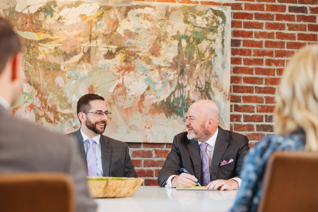 Brett Ewing seated with another person in a professional office setting.