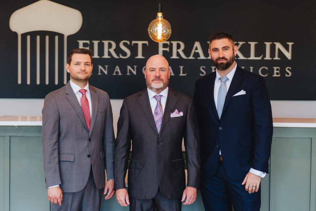 Brett Ewing posing with two people at First Franklin Financial Services.