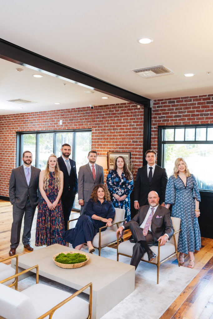 Brett Ewing pictured with a larger group in an office setting.